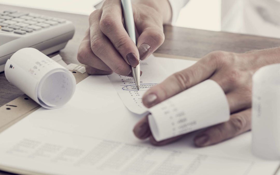 Person at desk going through receipts for tax preparation