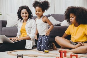 woman sitting at home with her two younger children