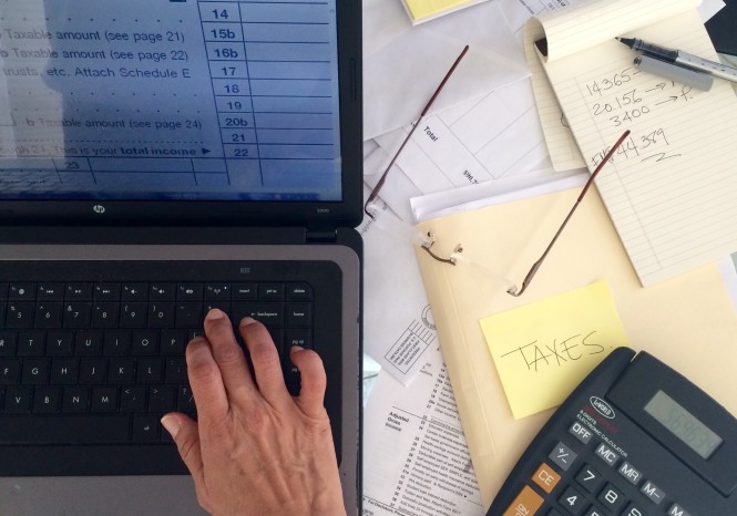 person at computer working on taxes